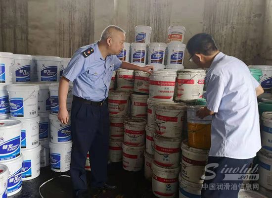 执法人员清理查封的假冒“长城”润滑油产品。