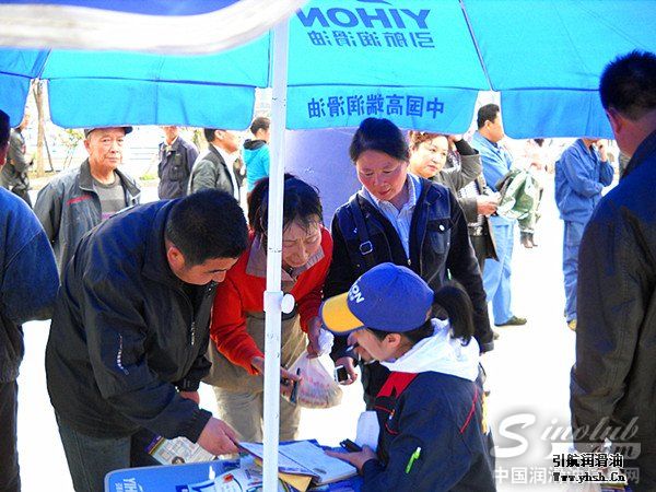 舞台车前的凉亭下，工作人员在接受行人关于引航油品特点的咨询