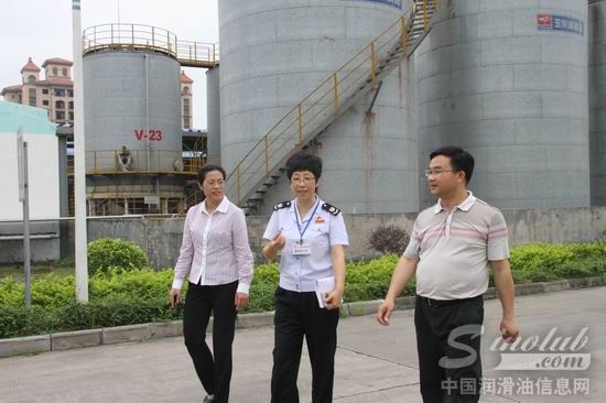 冯萍(左)、黄旭飞(右)带李小红(中)参观工厂